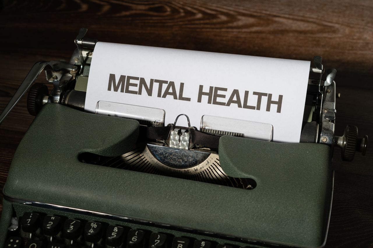 Close-up of a vintage typewriter displaying a mental health message on paper.